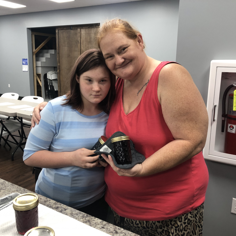  Mom and daughter holding jelly jars.